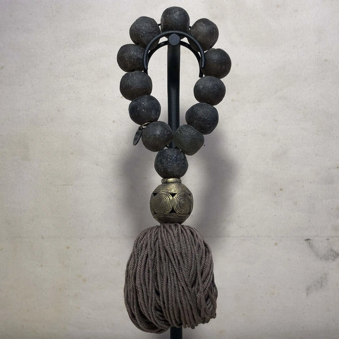 Large Julia Atlas objet d'art with dark brown recycled glass beads, decorative Nigerian bronze bead and brown grey cotton tassel. Total length is 12.5