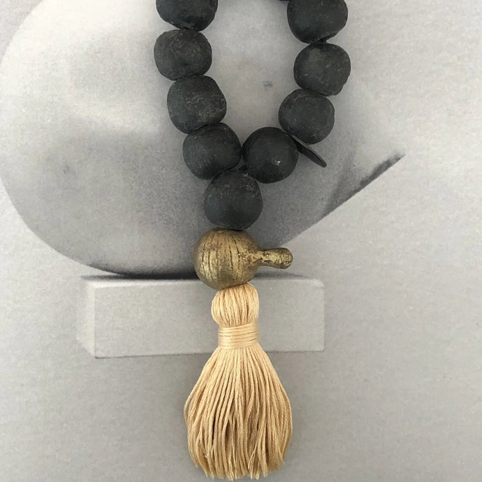 Mini Julia Atlas objet d'art with black recycled glass beads, rare replica bronzer of the King of Nigeria's necklace, and gold cotton tassel. Total length is 7.8